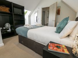 A bedroom with a bed and shelves at Budmouth near Weymouth