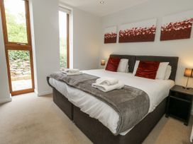A bedroom with a double bed and windows at Budmouth in Upwey near Weymouth