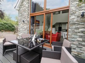 An outdoor patio area with a dining table and chairs at Budmouth in Upwey near Weymouth