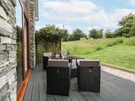 A garden with a table and chairs on a deck at Budmouth Upwey near Weymouth