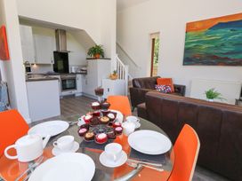 A kitchen with a dining table and cupcakes at Shepherd Oak in Upwey near Weymouth