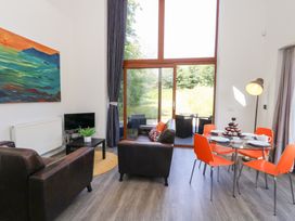 A living room with a sofa and dining area at Shepherd Oak Upwey near Weymouth