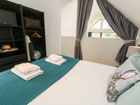 A bedroom with a bed and storage at Shepherd Oak in Upwey near Weymouth