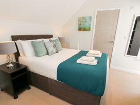 A bedroom with a bed and nightstand at Shepherd Oak in Upwey near Weymouth
