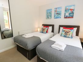 A bedroom with twin beds and wall art at Shepherd Oak in Upwey near Weymouth