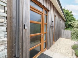 An entrance to a house with a wooden door and stone wall at Everdene Upwey near Weymouth