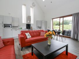 A living room with red sofas and a dining area at Everdene Upwey near Weymouth