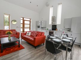 A living room with red sofas and a dining area at Everdene Upwey near Weymouth