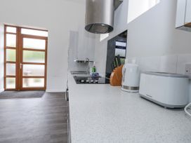 A kitchen featuring a sink, cooktop, and various appliances at Everdene Upwey near Weymouth