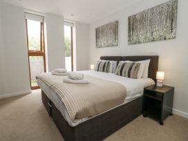 A bedroom with a bed and two windows at Everdene Upwey near Weymouth