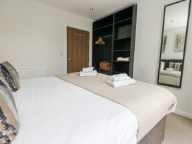 A bedroom with a bed and wardrobe at Everdene Upwey near Weymouth