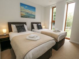 A bedroom with two beds and a window at Everdene in Upwey near Weymouth