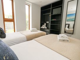 A bedroom with two beds and a mirror at Everdene Upwey near Weymouth