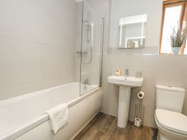 A bathroom with a shower and bathtub at Everdene in Upwey near Weymouth