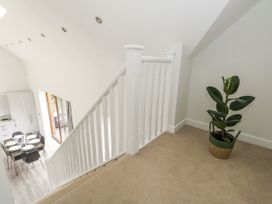 A staircase leading to a kitchen area with dining table at Everdene Upwey near Weymouth