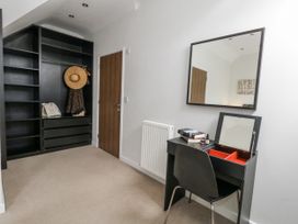 A bedroom with a desk and mirror at Everdene Upwey near Weymouth