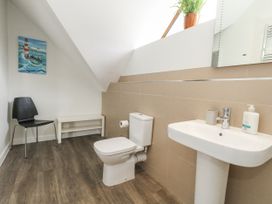 A bathroom with a toilet, sink, and chair at Everdene in Upwey near Weymouth