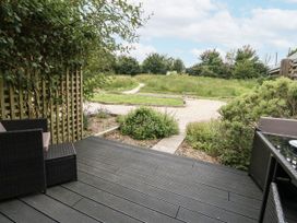 A patio area with chairs and a pathway leading to grass at Everdene Upwey near Weymouth