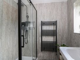 A bathroom with a shower and towel radiator at Red Kite Cottage Howey near Llandrindod Wells