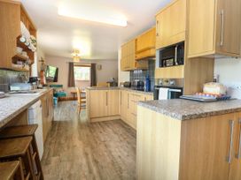 A kitchen with appliances and seating area at Dragonfly Lodge Whinburgh near Dereham