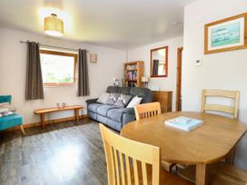 A living room with a sofa and dining table at Dragonfly Lodge in Whinburgh near Dereham