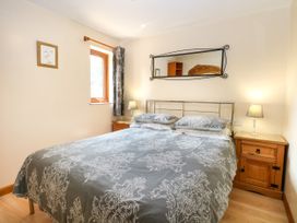 A bedroom with a bed and bedside tables at Dragonfly Lodge in Whinburgh near Dereham