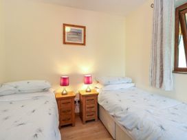 A bedroom with two beds and lamps at Dragonfly Lodge in Whinburgh near Dereham