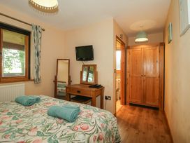 A bedroom with a bed and a mirror at Valley View Lodge Welshpool