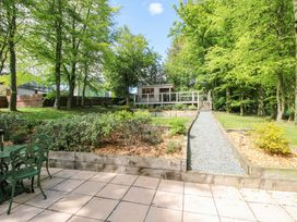 A garden with a gravel path leading to a wooden structure at Valley View Lodge in Welshpool