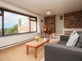 A living room with a sofa and coffee table at Tregiffian Vean in Sennen Cove