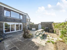 A garden with a patio and seating area at Tregiffian Vean Sennen Cove