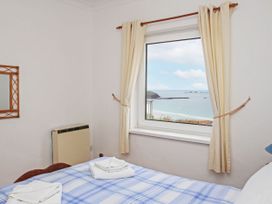 A bedroom with a window overlooking the sea at The Lookout in Sennen