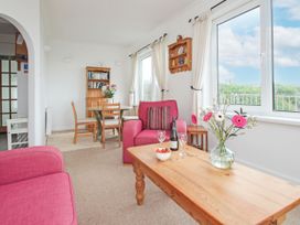 A living room with a pink sofa and wooden table at The Lookout in Sennen