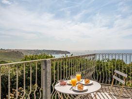 A table with croissants and orange juice on a balcony overlooking the sea at The Lookout in Sennen