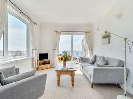 A living room with a sofa, armchair, and coffee table at The Lookout in Sennen