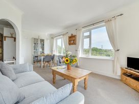 A living room with a sofa, table, and chairs at The Lookout in Sennen