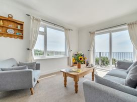A living room with a sofa, coffee table and flowers at The Lookout in Sennen