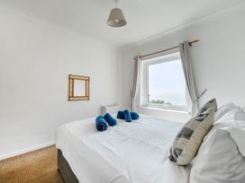 A bedroom with a bed and towels at The Lookout in Sennen