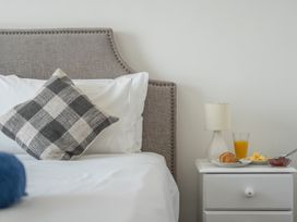 A bedroom with a bed and breakfast items on a nightstand at The Lookout in Sennen