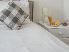 A bedroom with a pillow and breakfast items on a nightstand at The Lookout in Sennen