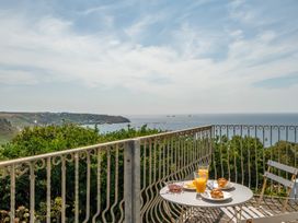 A breakfast table with orange juice and croissants overlooking the ocean at The Lookout in Sennen