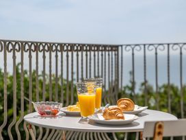 A table with orange juice and croissants on a balcony at The Lookout in Sennen