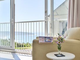 A living room with a sofa and glass table at Brook House Sennen Cove near St Just