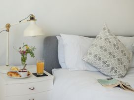 A bedroom with a bedside table holding a lamp and breakfast at Brook House Sennen Cove near St Just