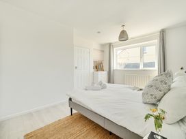 A bedroom with a bed and window at Brook House in Sennen Cove near St Just