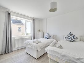 A bedroom with two beds and a window at Brook House Sennen Cove near St Just