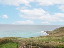 A view of the ocean with clouds and land at The Coach House in Sennen near St Just