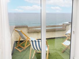 A balcony with deck chairs overlooking the ocean at The Coach House Sennen near St Just