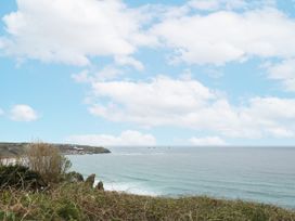 A coastal scene with ocean waves and clouds at The Coach House in Sennen near St Just