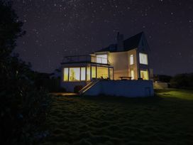 A house with illuminated windows at night at Carn Eve in Sennen Cove near St Just
